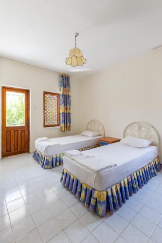 a room with two beds and a window at Flower Villa Apart in Kemer