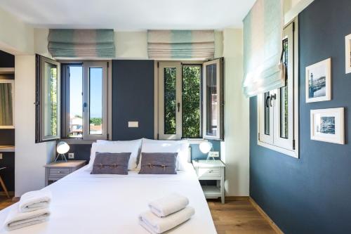 a bedroom with a large white bed with towels on it at Philoxenia Residences in Panormos Rethymno