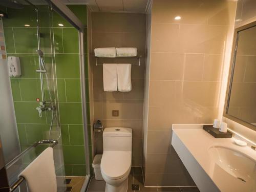 a bathroom with a toilet and a sink and a shower at GreenTree Inn Suqian Suyu District Red Star Macalline in Zhuoxu