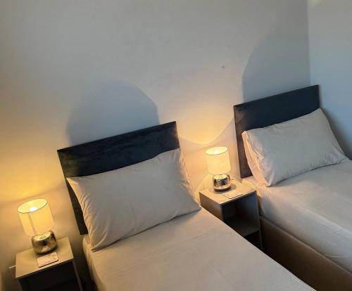 zwei Betten in einem Zimmer mit zwei Lampen darauf in der Unterkunft City Centre Apartment - Free Parking - Sleeps 4 in Exeter