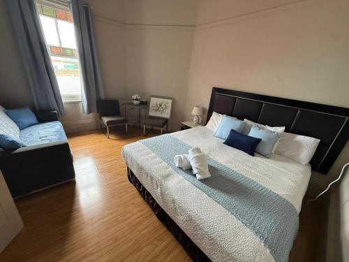 a bedroom with a large bed and a chair at Jerilderie Hotel - Pub, Restaurant & Accommodation in Jerilderie