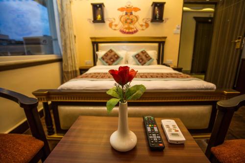 a red rose in a vase on a table in a hotel room at Hotel Encounter Nepal & Spa in Kathmandu