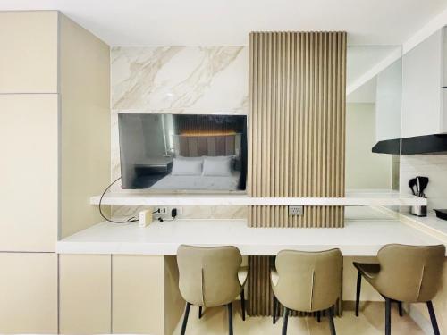 a kitchen with a counter with chairs and a bed at Bernwood Tower in Iloilo City