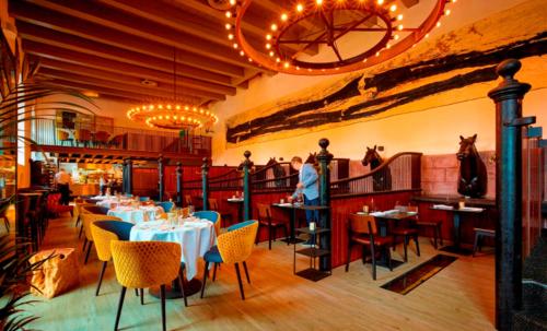 a dining room with tables and chairs in a restaurant at B&B Het Gasthuys in Amerongen