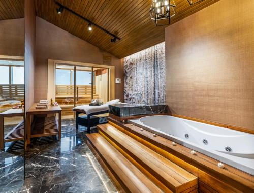 ein großes Badezimmer mit Badewanne und Waschbecken in der Unterkunft Kaya Palazzo Ski & Mountain Resort in Kartalkaya