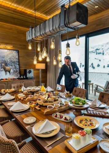 Een man die voor een tafel vol eten staat. bij Kaya Palazzo Ski & Mountain Resort in Kartalkaya