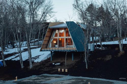 a cabin in the woods with a large glass window at SANU 2nd Home 山中湖1st in Yamanakako