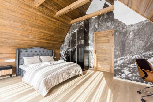 een slaapkamer met een bed en een houten wand bij Prywatna Sauna i jacuzzi! Tatra Spa Witów in Witów