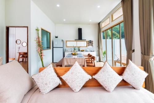 a living room with a couch with pillows at Amadha Villas Retreat - Free Tuk-Tuk Service To the Beach in Ao Nang Beach