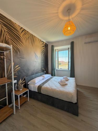 une chambre avec un grand lit et un lustre dans l'établissement Fly Inn Fiumicino Guest House, à Fiumicino