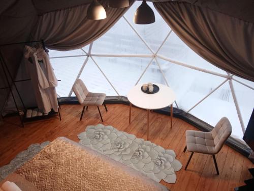 a room with a table and chairs and a large window at Глемпінг Перлина Карпат in Dragobrat