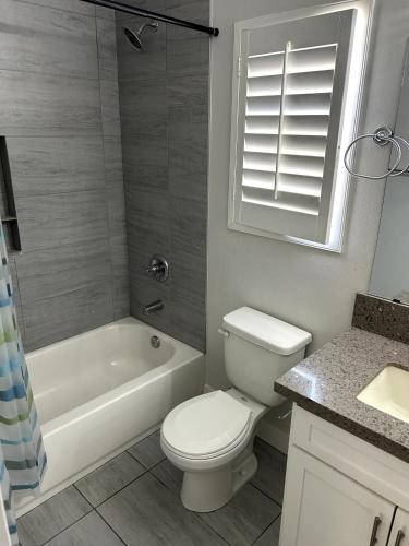 a bathroom with a toilet and a tub and a sink at Santa Ana Vibes in Santa Ana