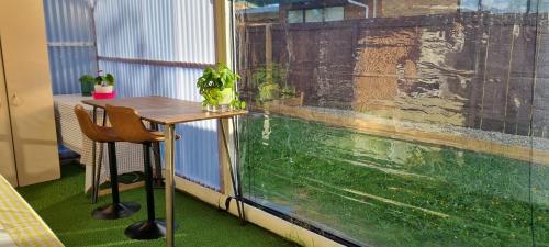 a table and chair next to a window with an aquarium at Natural Residence 天然居 in Auckland