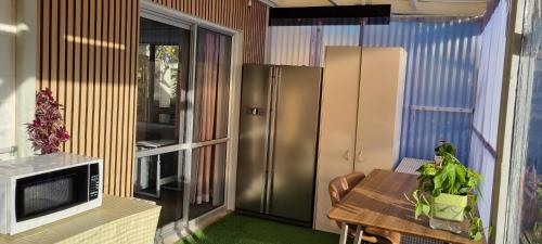 a kitchen with a table and a stainless steel refrigerator at Natural Residence 天然居 in Auckland
