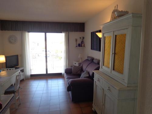 グリモーにあるappartement avec vue sur bateauのソファとガラスの引き戸のあるリビングルーム