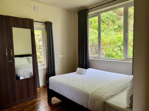 Un dormitorio con una cama y una ventana grande en Bloom Hill Ooty, en Ooty