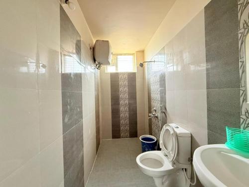 un baño con inodoro y lavabo en Bloom Hill Ooty, en Ooty