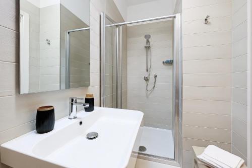 een witte badkamer met een wastafel en een douche bij Cantine Cippone Room in Monte SantʼAngelo