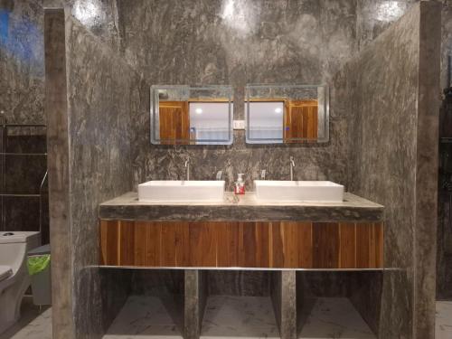a bathroom with two sinks and two mirrors at Kuba Bungalows in Ko Kood
