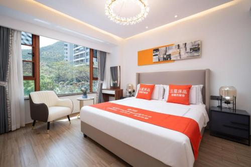a bedroom with a large bed and a chair at 来咖民宿酒店三亚市中心大悦城店 in Sanya