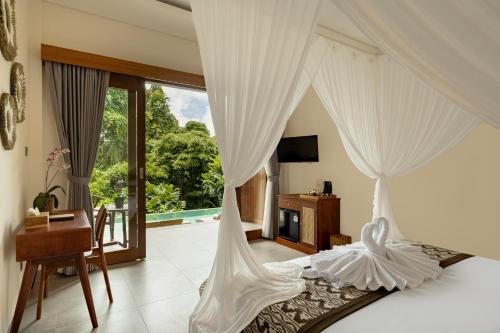 een slaapkamer met een bed met witte gordijnen bij Orchid Ubud Cottage in Ubud