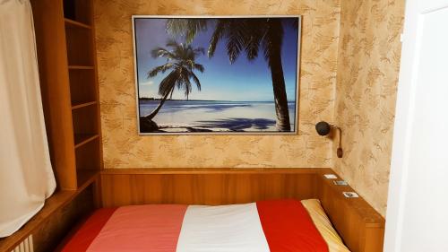 a bedroom with a bed with a picture of palm trees at Single Room In Very Quiet & Cosy House With Garden in Dübendorf
