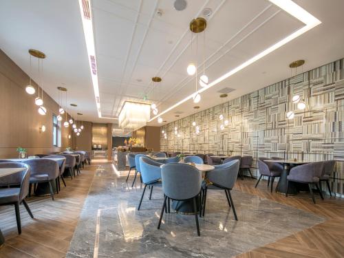 a dining room with tables and chairs and a wall of paper at Orange Hotel Beijing Zhongguancun Software Park in Beijing