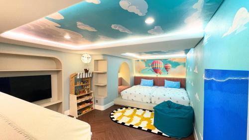 Ein Kinderzimmer mit einem Bett und einer Wolkendecke in der Unterkunft Ashley NewAir Menteng with Air Purifier in Jakarta