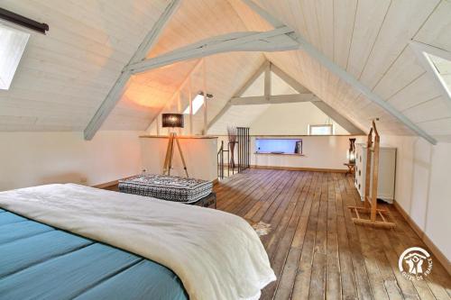 a bedroom with a large bed in a attic at Jardin de l'ardoiserie in Saint-Gravé