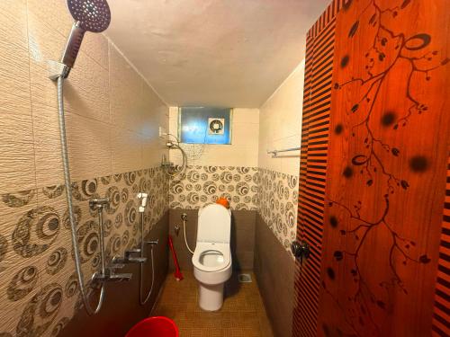 a small bathroom with a toilet and a shower at Wayanad Shas Villa in Padinjarathara