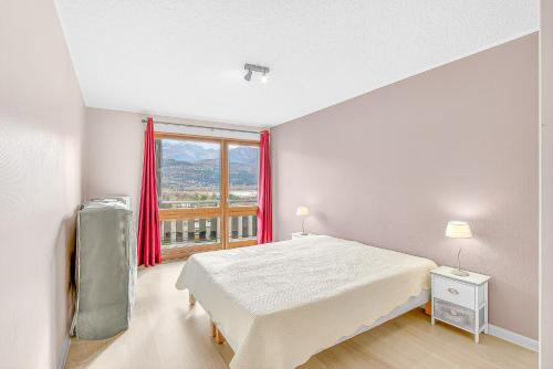 a bedroom with a bed and a large window at Appartement T3 in Embrun