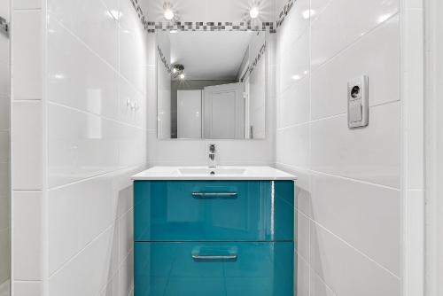 a bathroom with a blue cabinet and a mirror at Appartement T3 in Embrun