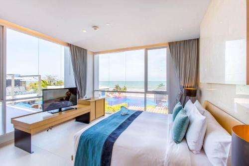 une chambre avec un lit et une télévision et un balcon dans l'établissement Ace of Hua Hin Resort - One Bedroom Ace Seaview Suite Private Pool, à Sathani Huai Sai Tai