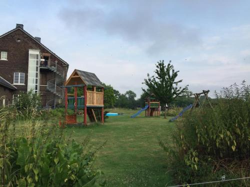une cour avec deux équipements de jeux et une maison dans l'établissement Neu! Alter Kornspeicher, à Bönen