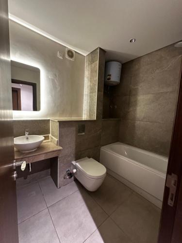 une salle de bain avec un lavabo, des toilettes et une baignoire dans l'établissement شقة فندقيه ابراج zedالشيخ زايد, à Sheikh Zayed