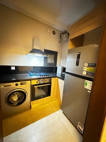 une cuisine avec un réfrigérateur et un lave-vaisselle dans l'établissement شقة فندقيه ابراج zedالشيخ زايد, à Sheikh Zayed