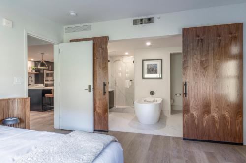 a bedroom with a bathroom with a tub in it at Main & SKY by EXMAR in Park City