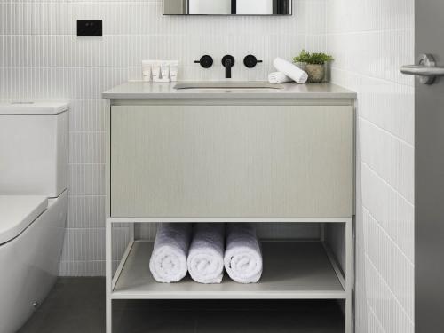 ボックスヒルにあるArt Series - The Chenの洗面台とタオルの棚を備えたバスルーム