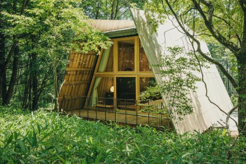 a house in the woods with a large window at SANU 2nd Home 八ヶ岳2nd in Hokuto