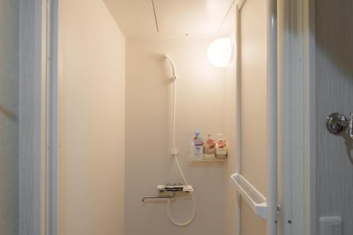 een badkamer met douche en toilet met licht bij Nihonbashi Glowview in Wada