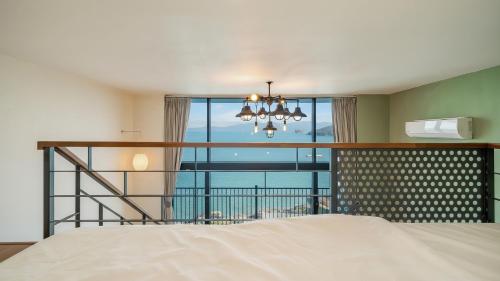 Un dormitorio con una cama y una ventana grande en Yeosu dasi bom pension, en Yeosu