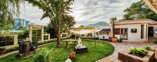 a house with a garden with a table and a patio at 忙碌的考拉Weeknd Hotel in Moujiakutao