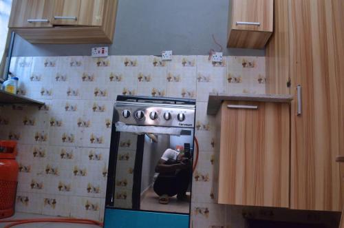 a kitchen with a stove with a person in it at Metroluxe in Akure