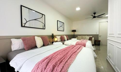 a room with three beds with pink and white blankets at Nadayu63 Melawati I 3R2B I 8Pax in Kuala Lumpur