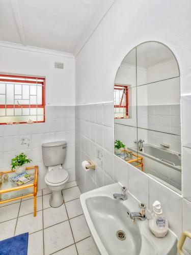 a white bathroom with a sink and a toilet at Marlyn 32 in Struisbaai