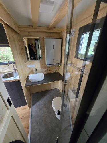a small bathroom with a toilet and a sink at Off-Grid Nature Tiny House Retreat & Simple Living in San Martino
