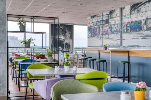 a restaurant with tables and chairs with a view of the ocean at ibis Berlin Messe in Berlin
