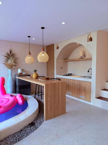 a kitchen with a table and a pink chair in a room at Andara Villa Yogyakarta in Yogyakarta