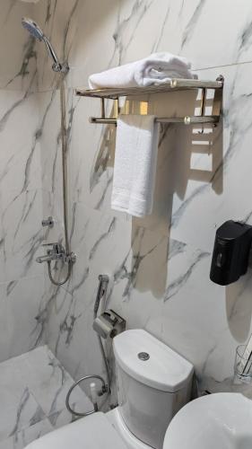 a white bathroom with a toilet and a sink at الفرسان المتحده للشقق المخدومه الفيصليه ALFURSAN ALMOTAHIDA ALFAISALIA dist in Jeddah