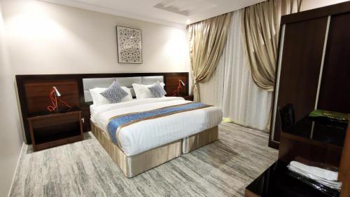 a hotel room with a large bed and a window at الفرسان المتحده للشقق المخدومه الفيصليه ALFURSAN ALMOTAHIDA ALFAISALIA dist in Jeddah